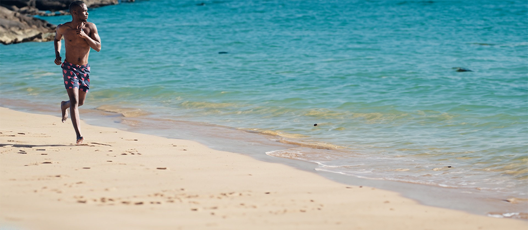 All the Love trunks on a male model running in the sand along a beach